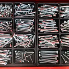 Szuflada z przegródkami pełna śrub i nakrętek, gotowych do użycia. Solidne mocowanie dla każdego projektu.