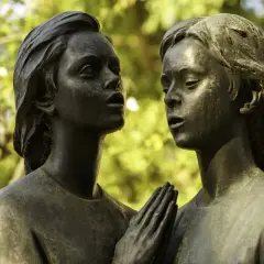Deux anges en bronze, œuvre d'un fondeur d'art, se regardent tendrement. Leurs mains jointes évoquent une prière silencieuse.