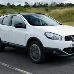 Vit Nissan Qashqai kör på en kurvig väg. En förare syns bakom ratten. Kanske ett problem med bilen?