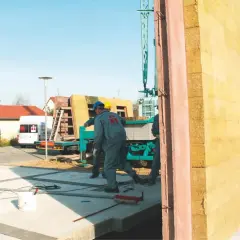 Budowa domu z keramzytu. Pracownicy montują prefabrykowane ściany.