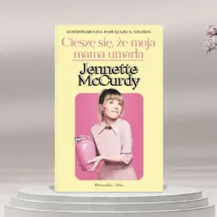 Okładka książki "Cieszę się, że moja mama umarła" Jennette McCurdy. Aktorka trzyma różową urnę.