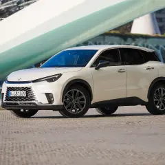 Biały Lexus LBX na tle nowoczesnej architektury. Sprawdź jego lexus lbx dane techniczne i odkryj możliwości tego miejskiego SUV-a.