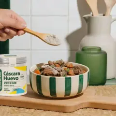 Un suplemento de cáscara de huevo se añade a la comida de un perro. ¡Los perros pueden comer huevo!