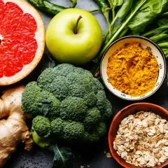 Bunte Auswahl an Lebensmitteln wie Grapefruit, Brokkoli, Avocado, Ingwer und Gewürzen, die wichtige Mineralstoffe liefern.