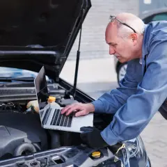 Mechanik diagnozuje awarię pojazdu Opel Astra J za pomocą laptopa. Skontaktuj się z serwisem Opel Astra J w razie problemów.