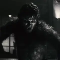 Un loup-garou Marvel aux yeux jaunes et aux crocs menaçants, prêt à bondir dans la pénombre.
