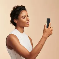 Donna con smartphone, utile per capire come scegliere fondotinta online.