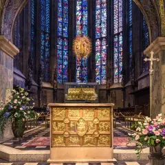 Wnętrze katedry z witrażami, ołtarzem i kwiatami. W tle złota monstrancja, przypominająca o tęsknocie z psalm 137 tekst.