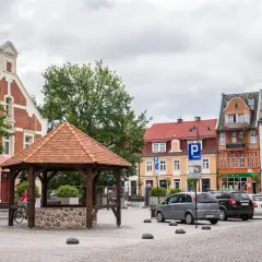 Rynek w Starogardzie Gdańskim, stolicy Kociewia, z drewnianą studnią i kolorowymi kamienicami.