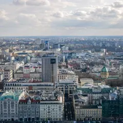 Rozległa panorama miasta, widok na warszawską dzielnicę z licznymi budynkami, w tym wieżowcem z napisem "Love".