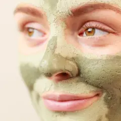 Primo piano di un volto con maschera all'argilla verde. Scopri a cosa serve l'argilla verde per la tua pelle.