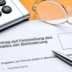 Antrag auf Feststellung des Grades der Behinderung, mit Brille, Taschenrechner und Stift. Wichtig für die Einschätzung des osteochondrose behinderungsgrad.