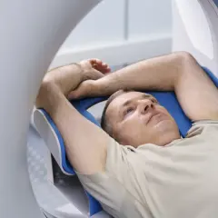 Mężczyzna leży w rezonansie magnetycznym. Zastanawia się, czy przed rezonansem można jeść.