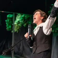 Aktorka z Teatru Lalki i Aktora w Opolu krzyczy do mikrofonu, prezentując emocjonujący fragment repertuaru.