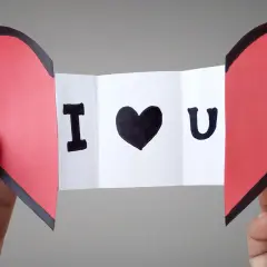Cuore rosso diviso a metà, con un biglietto che dice "I ♥ U". Un'idea per i san valentino lavoretti fai da te.