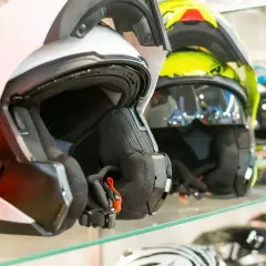Cascos de moto de varios colores, incluyendo un casco no integral blanco en primer plano, listos para la aventura.