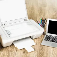 Drukarka, laptop i telefon leżą na drewnianym biurku. Zastanawiasz się, czy można podłączyć drukarkę do telefonu?