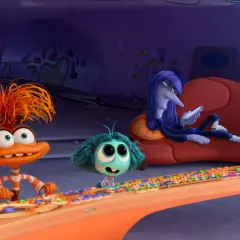 Hier ist alles steht kopf 2 emotionen: Ein orangefarbenes Wesen mit struppigen Haaren drückt Knöpfe, ein kleines blaues Wesen schaut neugierig, während ein langes, blaues Wesen auf einer Couch liegt und auf sein Handy schaut.
