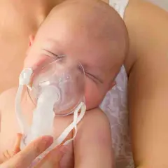 Bambino con maschera per inalazione, un aiuto per la tosse.