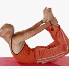 Hombre en postura del arco yoga, estirando su espalda y piernas.