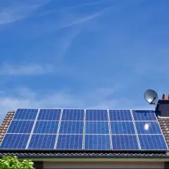 Panele fotowoltaiczne na dachu domu, symbolizujące długą żywotność i ekologiczne pozyskiwanie energii.