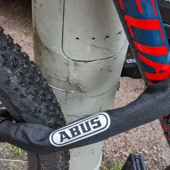 Fahrrad diebstahlschutz: Ein ABUS Kettenschloss sichert das Rad an einem Pfosten.