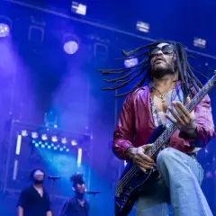 Lenny Kravitz 2023 rockt die Bühne mit seiner Bassgitarre, die Dreadlocks fliegen im Scheinwerferlicht.