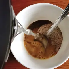 Gorąca woda zalewa kawę rozpuszczalną w kubku. Zastanawiasz się, ile mg kofeiny ma kawa rozpuszczalna?