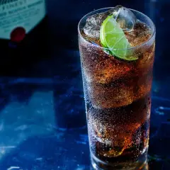 Orzeźwiający drink z whisky i colą, z plasterkiem limonki. Idealny pomysł, z czym pić whisky na wieczór.