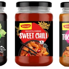 Trzy słoiki sosów Winiary: Teriyaki, Sweet Chili i Tikka Masala, z widokiem potraw.