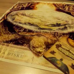 Plakat i książka "Świat Dysku" Terry'ego Pratchetta przedstawiają Wielkiego A'Tuina, kosmicznego żółwia niosącego świat.
