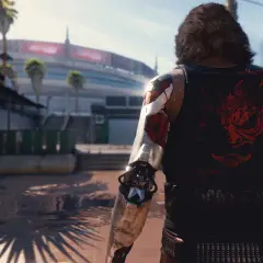 Cyberpunk 2077 ile godzin? Postać z cybernetycznym ramieniem i koszulką z logo Samurajów stoi na tle futurystycznego miasta.