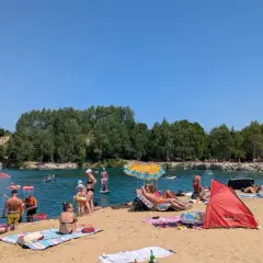 Słoneczny dzień nad zalewem Balaton Trzebinia. Ludzie odpoczywają na plaży, pływają i relaksują się w wodzie.