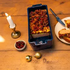 Une terrine maison aux airelles, servie sur toasts avec une bougie allumée. Une ambiance festive pour un délice.