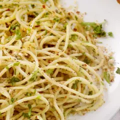 Un piatto di spaghetti alla carrettiera, conditi con aglio, olio, peperoncino e prezzemolo fresco, con una spolverata di pangrattato tostato.