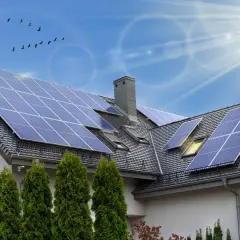 Instalacja fotowoltaiczna 6 kW cena z montażem na dachu domu. Słoneczny dzień, ptaki na niebie.