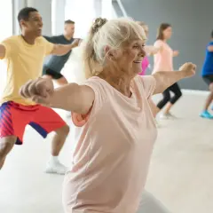 Animation ehpad : des seniors actifs et souriants participent à un cours de danse dynamique, montrant que l'âge n'est pas une barrière à la joie de bouger.