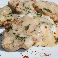 Schab w mleku, podany z ryżem i posypany koperkiem i papryką, wygląda apetycznie.