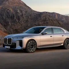 Luksusowy sedan BMW i7, lider rankingu samochodów elektrycznych, na tle surowych górskich krajobrazów.