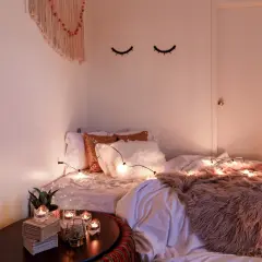 Gemütliches Schlafzimmer mit Lichterkette und Kissen. Tolle geschwister zimmer teilen ideen für eine kuschelige Atmosphäre.