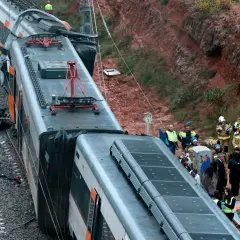 Olycksplats med ett urspårat tåg i Spanien. Räddningspersonal undersöker vraket.