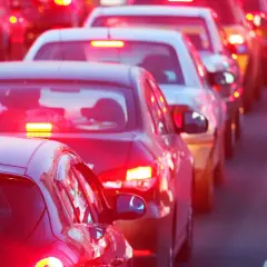Voitures à l'arrêt dans un embouteillage, leurs feux de position seuls illuminent la route.