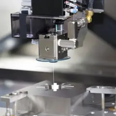 Precyzyjna obróbka elektroerozyjna drutowa tworzy skomplikowane kształty w metalowym bloku.