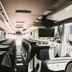 Wnętrze autobusu, gotowego na podróż z Poronina do Zakopanego. Puste siedzenia czekają na pasażerów.