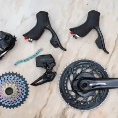 SRAM news: A new Force AXS groupset with rainbow cassette, crankset, derailleurs, and shifters laid out on a marble surface.