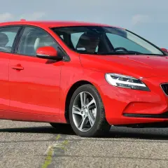 Czerwone Volvo V40 D2 z polskimi tablicami rejestracyjnymi jedzie po asfaltowej drodze.