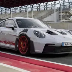 Biały Porsche 911 GT3 RS na torze wyścigowym. Sprawdź, jaka jest porsche 911 gt3 rs cena i poczuj moc tego auta.