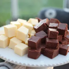 En vit bricka med staplade bitar av ljus och mörk fudge. Perfekt för ett enkelt fudge recept.