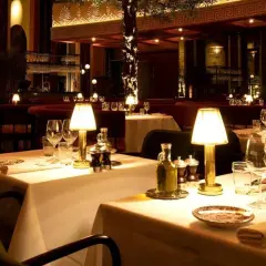 Ett elegant dukat bord med tända lampor, glas och olivolja. En inblick i en av Stockholms trendiga restauranger.
