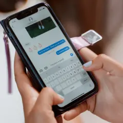 Kobieta pisze wiadomość na telefonie, pokazując, jak uruchomić Messengera.